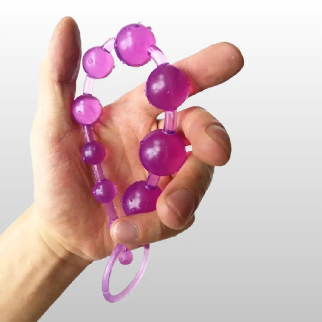 Purple anal beads held in hand with flexible body-safe design