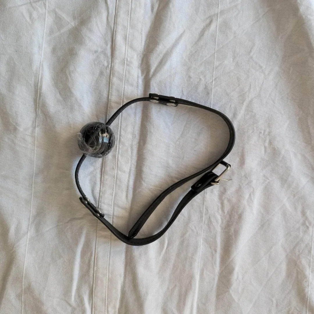 Black Mouth gag on light beige fabric background