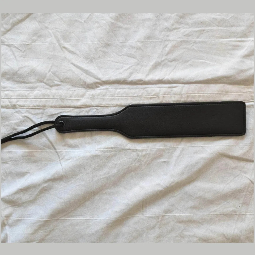 Black paddle on a white textured surface