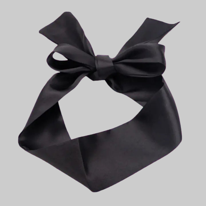 Black satin bow on a pink background